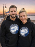 Garrett and Savannah wearing matching black Gulf of America retro map hoodies on a Gulf Coast fishing pier at dusk