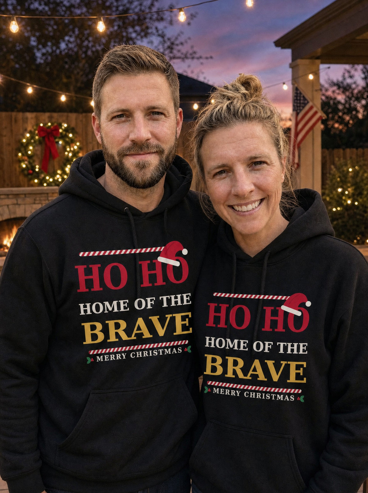 Garrett and Savannah smiling in matching black Ho Ho Home of the Brave Christmas hoodies by a backyard fire pit under string lights at dusk (AI-generated photo)