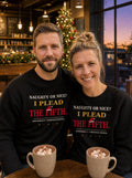 Garrett and Savannah in matching black I Plead the Fifth Christmas Edition sweatshirts with a Santa hat graphic, holding hot cocoa in a decorated coffee shop at dusk